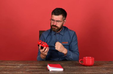 Kupası, retro saat ve vintage masa üzerinde kırmızı kitap