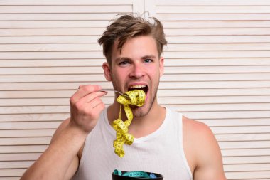 Bej rengi jaluzinin arka planına odaklanmış bir adam.