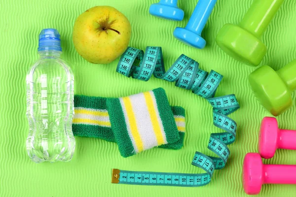 Súlyzók, alma, vizes palackot és cián mérjük tape — Stock Fotó