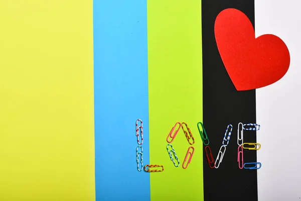 Червоний папір серце і слово "LOVE" на барвистому фоні — стокове фото