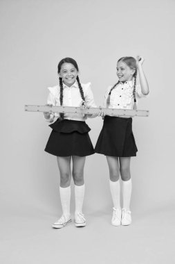 Geometri favori konu. kök disiplinler. Okula geri dön. Matematik ve geometri. Üniformalı çocuklar. okul arkadaşlığı. mutlu küçük kızlar matematik çalışır. öğrenciler sarı cetvel kullanın