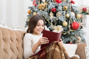 Edebiyat kulübü. Noel ruhu. Küçük okuyucu evde okumayı sever. En iyi Noel kitabı. Kitapçı reklamı. Küçük gülümseyen çocuk kitap okuyor. Yeni yıl arifesi. Küçük kız Noel hikayesi okuyor.