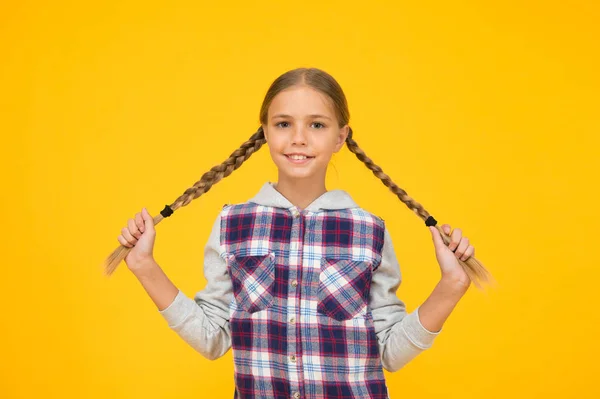 Kind lange Haare. kleines Mädchen kariertes Hemd. fröhlicher internationaler Kindertag. kleines Mädchen gelbem Hintergrund. Gute-Laune-Konzept. positive Stimmung. Aufrichtige Emotionen. Spaß haben. Nettes geflochtenes Mädchen — Stockfoto