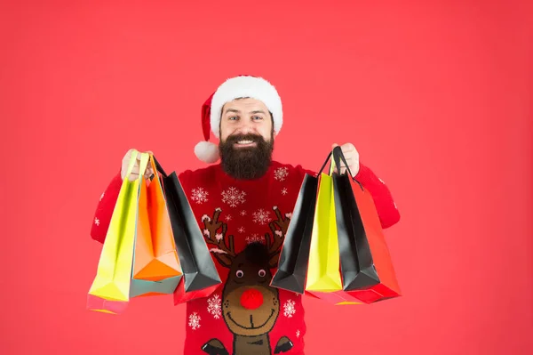 Satın almaktan tasarruf et. Mutluluktan alışveriş. Sakallı hippi adam kış süveteri giyer alışveriş torbaları taşır. Yeni yıl hediyeleri al. Hediye alışverişi. Güzel alışveriş. İndirimli kulüp üyeleri. Ek hizmetler — Stok fotoğraf