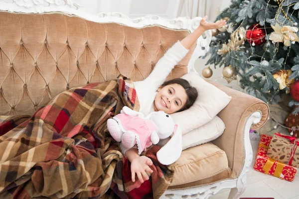 Christmas eve. Dreaming about christmas miracle. Small cute girl dreaming about christmas gift. Happy childhood. Small kid. Kid lay sofa dreaming about christmas present. Winter dream concept