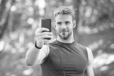 Telefondaki spor uygulaması. Dijital spor. Akıllı saat. Spor giyim sektöründeki atletik adam selfie çekiyor. Açık hava antrenmanı. Fitness uygulaması. Ui ux kavramı. Modern sporda bir alet. İz sürücüdeki kaslı adam. bağlantı araması