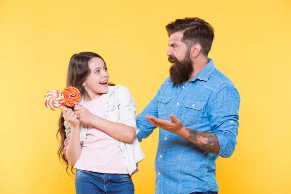 Snoep delen. Dochter en vader eten snoep. Een bebaarde hipster is een goede vader. Kleurrijke lolly van klein meisje en vader. Zomer vibes. Een gelukkig gezin. Vrolijk over het dessert. snoepwinkel. gelukkige jeugd — Stockfoto