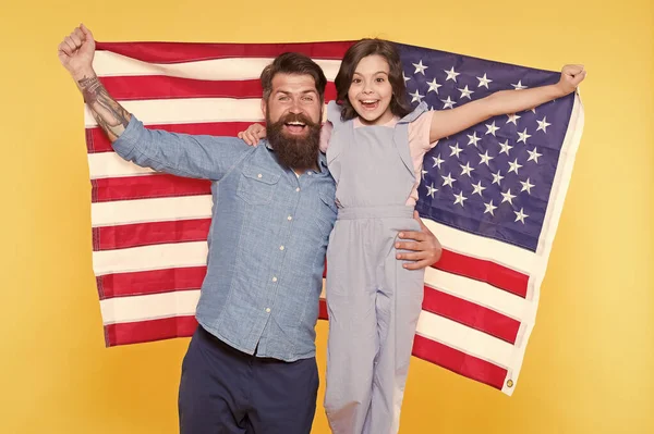 La independencia es felicidad. ¿Cómo celebran los americanos el día de la independencia? Padre barbudo hipster y linda hijita con bandera de EE.UU.. Familia patriótica alegre y amigable. Día de la independencia vacaciones — Foto de Stock