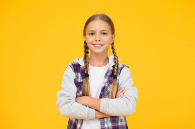 Sıradan bir tarz. Küçük kız sarı arka plan. Keyif konsepti. Pozitif titreşimler. Kendine güven. Güzel örgülü kız. Uzun saçlı çocuk. Küçük kız kareli gömlek. Uluslararası Çocuk Gününüz kutlu olsun.