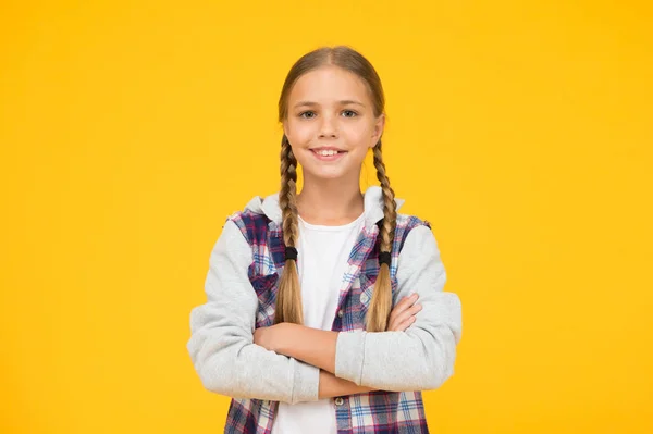 Απλό στυλ. Κοριτσάκι κίτρινο φόντο. Καλή διάθεση. Θετικές δονήσεις. Αυτοπεποίθηση Χαριτωμένο πλεκτό κορίτσι. Μακριά μαλλιά. Μικρό καρό πουκάμισο κοριτσιού. Ευτυχισμένη διεθνής ημέρα των παιδιών — Φωτογραφία Αρχείου