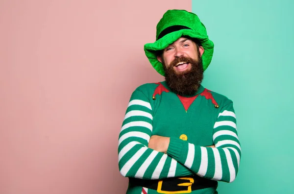 Christmas elf. Elf concept. Traditions or customs. Happy celebration. Bearded elf. Winter carnival. St Patricks day. Hipster with beard wearing green costume for party. Cheerful man celebrate holiday