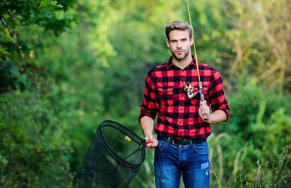 Jour de pêche. Beau gars en chemise à carreaux avec équipement de pêche fond de la nature. Pêcher dans mon passe-temps. Pêcheur hipster avec filet à canne. Espérons une belle pêche. Concept week-end d'été — Photo