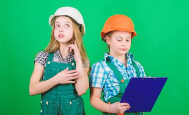 Tabletli kasklı küçük çocuklar. İşçi bayramı. 1 mayıs. küçük kızlar atölyede birlikte tamir. Foreman müfettişi. Onarım. okul projesi. kask ve tablet tüm iş için ihtiyacınız