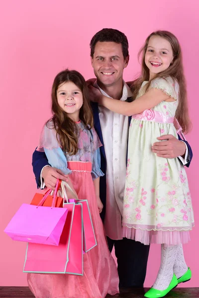 Schoolgirls in dresses and father hold packets. Shopping and presents — Stock Photo, Image