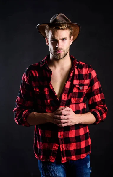 Cowboy life came to be highly romanticized. Masculine ideal. Western life. Masculinity and brutality concept. Adopt cowboy mannerisms as a fashion pose. Man unshaven cowboy black background