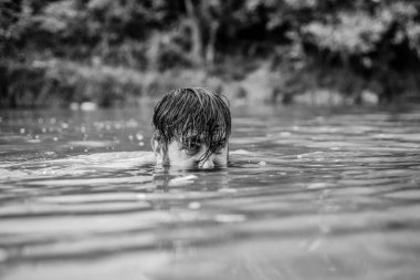 Derin tehlikeli su. Rahatlama ve dinlenme. Yüzme sporu. Yüzme becerileri. Ferahlatıcı bir duygu. Adam nehir veya gölde yüzme keyfini çıkarın. Suya daldırın. Vahşi doğanın tazeliği. Yaz tatili