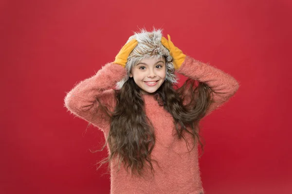 Keep head in warm. holiday activity outdoor. small child ready for winter. seasonal health care. kid fashion. Warm clothes and accessory tips. happy little girl in earflap hat. Happy girl touch hat — Stock Photo, Image