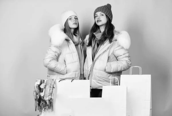 Having fun together. Black friday. Buy winter clothes. Sale and discount. Women friends shopping winter clothes. Shopping guide. Faux fur. Girls wear warm jackets. Shopping concept. Shopping bags