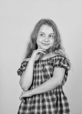 Young and beautiful. long blond curly hair. beautiful little girl fashion model. small kid in dress. happy small girl with long healthy hair. hair health and care. hairdresser salon. kid fashion