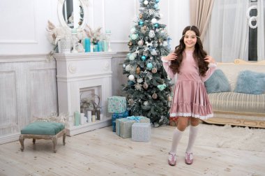 Yeni yıl arifesi. Tatil kutlaması. Aksesuar ve mücevherlerle donatılmış. Zenginlik ve refah. Şirin ve göz kamaştırıcı. Mutlu Noeller kızım. Xmas bakışlı küçük kız. Noel ağacında küçük bir kız