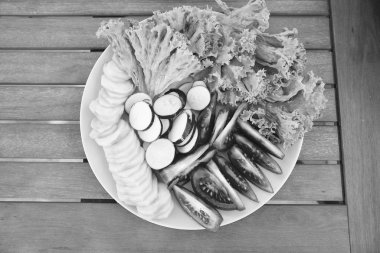 Tazeliğin tadı. Tabakta taze sebze. Bahar salatası. Doğranmış domates salatalık turp ve marul. Taze salata ev yapımı organik sebzelerden yapılır. Vejetaryen yemek konsepti. Taze gıda