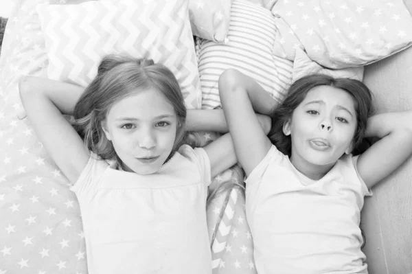 Η έννοια της αδελφότητας. Μοιραζόμαστε μυστικά. Τα παιδιά χαλαρώνουν στο κρεβάτι. Αδελφές ετοιμάζουν ύπνο. Ωραία βραδιά. Καλύτεροι φίλοι. Παιδιά φίλοι. Τα χαριτωμένα παιδάκια έχουν ελεύθερο χρόνο πριν κοιμηθούν. Καλύτεροι φίλοι διαλόγου — Φωτογραφία Αρχείου