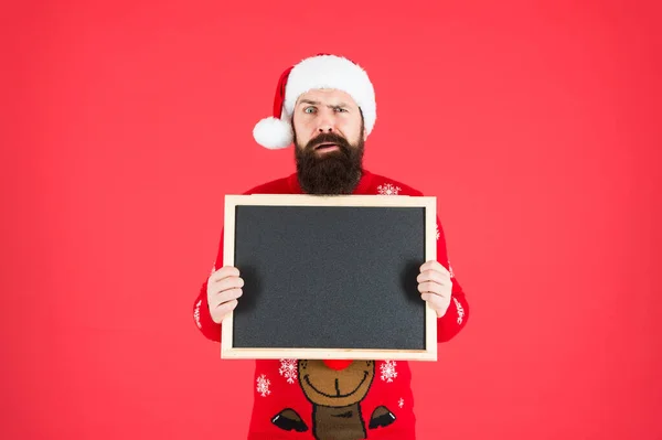 Παρουσιάζουμε το προϊόν. Άγιος Βασίλης κρατήσει άδειο πίνακα κόκκινο φόντο. Διαφημιστικό προϊόν Beared man. Περιγραφή του προϊόντος. Σημαντικές πληροφορίες σχετικά με το προϊόν είναι εδώ, αντίγραφο χώρου — Φωτογραφία Αρχείου