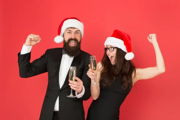 Couple amoureux à la fête. Bonne année. Homme barbu en smoking et fille robe élégante boire du vin mousseux et danse fond rouge. Fête d'hiver. Des gens joyeux. Joyeux Noël. Parti de bureau — Photo