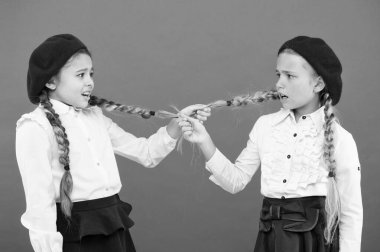 Okul kabadayıları. Pembe arkaplanda kızları zorba. Okulda pigtails çeken zorba sınıf arkadaşları. Zorba veya zorbalık