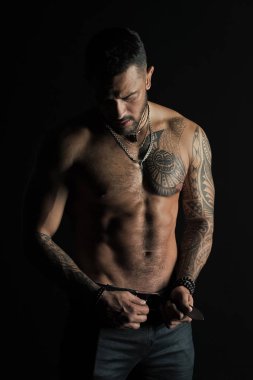 Sakallı adam gömleksiz fit vücut'la. Dövme tasarım cilt üzerinde olan adam. Kot pantolon moda model toka deri kemer. Sporcu altı paketi ve AB Fitness Spor ve ilgilenmek ile