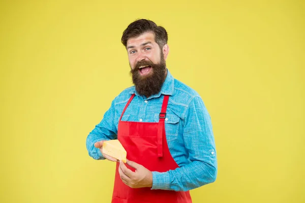 Lactosa. Producto gourmet. Productos lácteos derivados de la leche. Técnicas de elaboración de queso. Compras en línea. Dieta y nutrición. Concepto de hacer queso. Fabricante de quesos. Barbudo hombre en delantal mantenga pedazo de queso —  Fotos de Stock