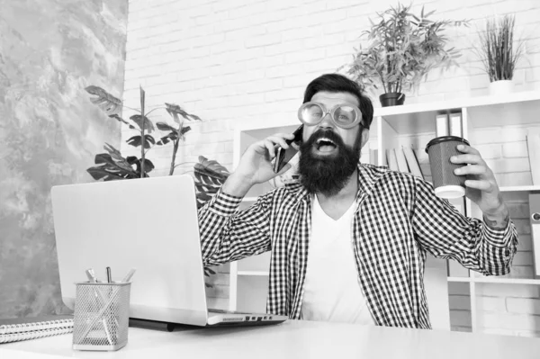 Cup of coffee is really about communication. Bearded man communicating by smartphone. Hipster working on computer with wireless communication in office. Using mobile communication. Communication — Stock Photo, Image