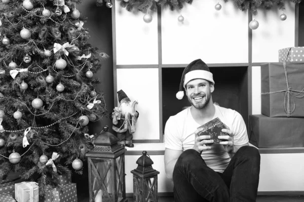 Macho sonrisa con caja de regalo en el árbol de Navidad — Foto de Stock