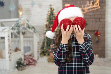 Oyuncu çocuk. Çocuk Noel Baba şapkası süsleme ağacı. En sevdiği aktiviteyi süslüyor. Dekoratör. Evi dekore et. Noel ağacı toplarını süsleyen çocuk. Noel ağacı süsleyen kız.