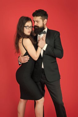 Günaha. aşık seksi çift. smokin ve siyah elbiseli formanl çift. zarif moda ve güzellik. romantik tarih. iş ortaklığı. resmi olay. ayartma ve arzu. ayartma çift