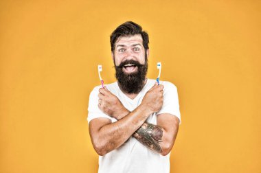 Plaket ve tartardan kurtul. Mutlu hipster diş fırçası tutuyor. Sakallı adam diş fırçasıyla gülümsüyor. Diş sağlığı. Diş ve diş etleri sağlıklıdır. Sağlıklı bir ağız. Oral sağlık hizmeti. Diş sağlığını etkiler.