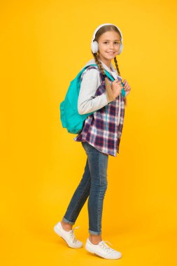 Öğrenci. Modern eğitim. Enerjik neşeli genç müzik dinliyor. Şık liseli kız okula gidiyor. Sırt çantalı, şık bir kız. Okul hayatı. Mutlu tasasız çocuk. Okul sınıfları