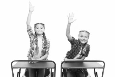 Çalışma sürecinin keyfini çıkarın. Küçük kızlar okul arkadaşları birlikte çalışır. Cevap vermek için ellerinizi kaldırın. Öğrenciler sınıf arkadaşları masa başında. Okula geri dön. Özel okul konsepti. İlkokul eğitimi