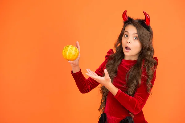 Wat fantaseer je voor Halloween? Verrast meisje houden kleine pompoen oranje achtergrond. Creatieve fantasie. Fantasie en magie. Dat is fantasie denken, kopieer ruimte. — Stockfoto