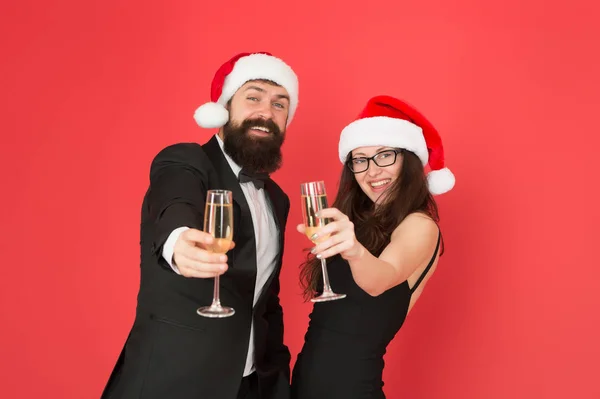 Lets have fun. Office party. Couple at corporate party. Happy new year. Bearded businessman in tuxedo and girl elegant dress drinking sparkling wine red background. Winter party. Merry christmas