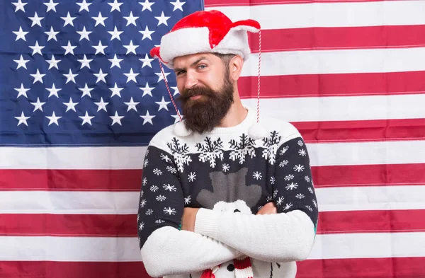 Brutale man draagt gebreide trui. Amerikaanse traditie. Baard hipster Amerikaanse vlag achtergrond. Kerstmis nieuwjaar. Geest van patriottisme. Kersttraditie uit de Verenigde Staten van Amerika. Amerikaanse douane — Stockfoto