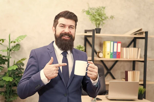 Man bebaarde zakenman houdt koffie beker stand kantoor achtergrond. Succesvolle mensen drinken koffie. Koffie drinken ontspannende pauze. Baas geniet van energiedrank. Cafeïne verslaafd. Startdag met koffie — Stockfoto