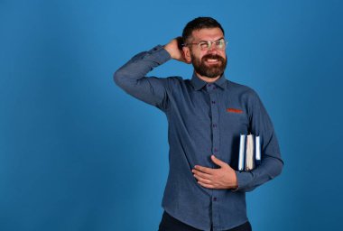 Öğretmen gözlük takıyor ve ders kitaplarını tutuyor. Bilgi ve ders.