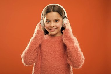 Yeni bir ses teknolojisi geliyor. Kablosuz stereo kulaklık takan küçük kız. Modern teknoloji. Teknoloji ve müzik. Stereo ses teknolojisi