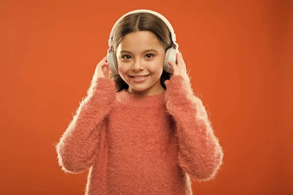Nadchodzi nowa technologia audio. Mała dziewczynka nosi bezprzewodowe słuchawki stereo. Nowoczesna technologia. Technologia i muzyka. Technologia dźwięku stereo — Zdjęcie stockowe