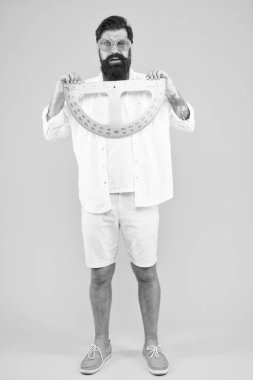 Derse hazır olmak. Sakallı adam matematik dersi için protractor tutarak. Matematik öğretmeni veya geometri dersine hazırlanan öğrenci. Hipster okul dersinde ölçüm aleti kullanarak