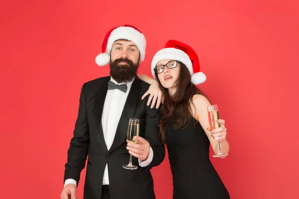 Festa di Capodanno. Festa dell'ufficio di Natale. amano il nuovo anno. concetto di auguri. cerimonia formale di visita coppia evento. smoking uomo con donna in cappello da Babbo Natale. Buon Natale a tutti. coppia d'affari bere champagne — Foto Stock