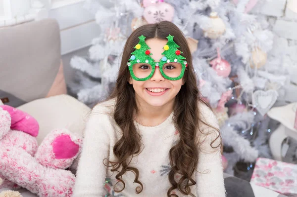 Buenas vibraciones. Vacaciones de invierno. Niño relajado. Adorable niña usar gafas de árbol de navidad foto cabina utilería. Descansa y relájate. Nochebuena. Niña pequeña en casa vacaciones de Navidad. Niñez despreocupada — Foto de Stock