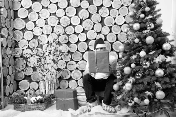 Hombre en santa hat peep sobre caja roja en trineo — Foto de Stock