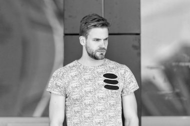 Modern hayat. Maço adam cam bina arka planı. Erkek modası yaz trendi. İradeli erkek. Tıraşsız bir adam cildini ve sakalını önemser. Berber dükkanı konsepti. Kaslı adam şehirli tarzı. Hayatın sıradan bir günü